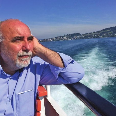 Salvo Adamo a bordo di un battello, appoggiato al parapetto, con la scia sull’acqua alle spalle